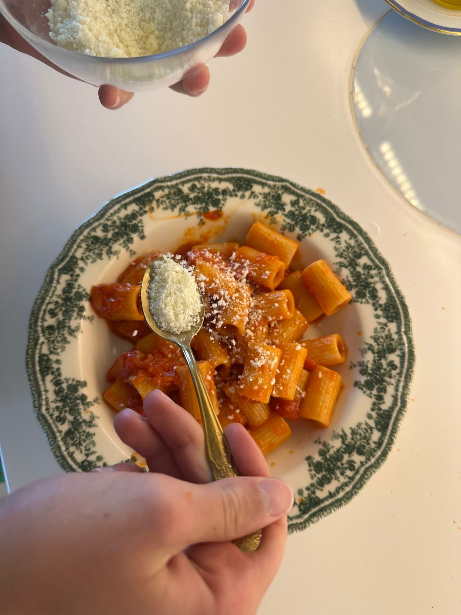 Parmigiano grattugiato sulla pasta al pomodoro